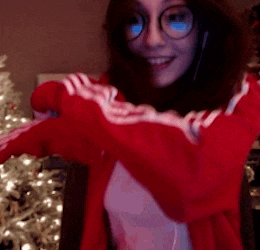 a woman wearing glasses and a red jacket is smiling
