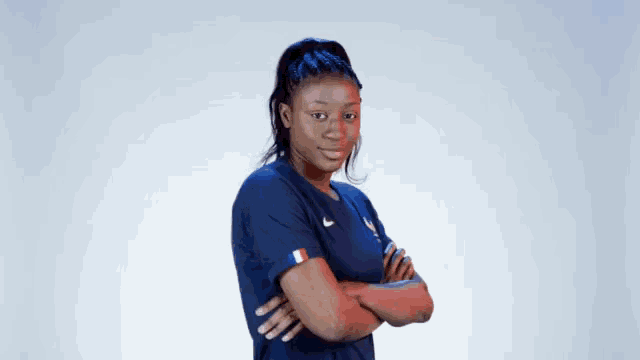 a woman with her arms crossed is wearing a nike shirt