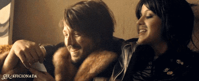 a man and a woman are sitting next to each other with the words gif4ficionada written on the bottom