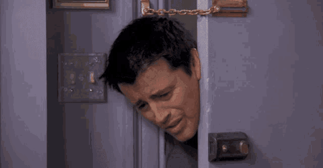 a man is peeking out of a door and the word interesting is on the bottom right