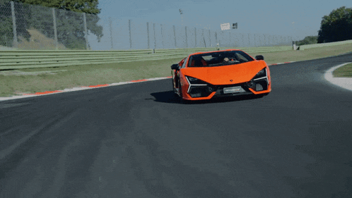 a red lamborghini is driving down a race track