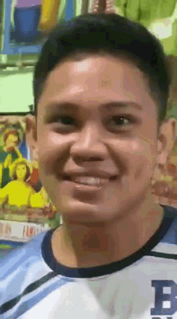 a man wearing a blue shirt with the letter b on it