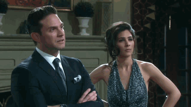 a man in a suit and tie standing next to a woman in a dress