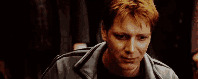 a close up of a man with red hair wearing a jacket .