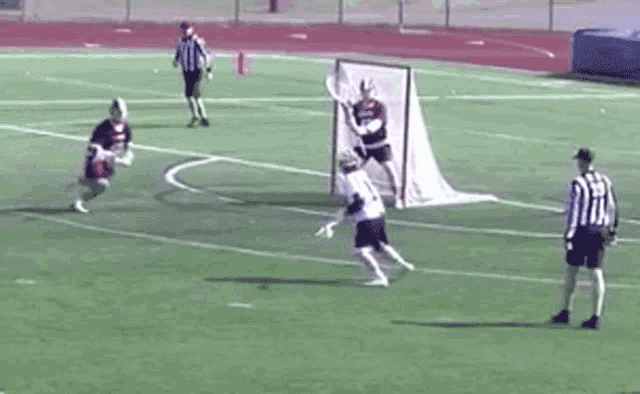 a lacrosse game is being played on a field with a referee .