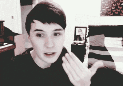 a young man in a black shirt is making a funny face while talking on a video call .