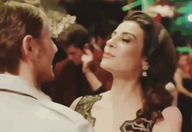 a man and woman are dancing together in a club .