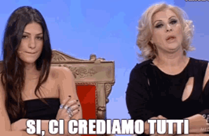 two women sitting next to each other with the words si ci crediamo tutti