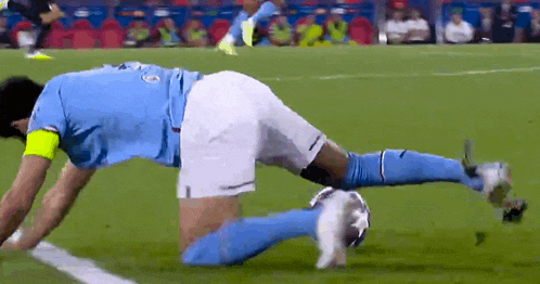 a soccer player in a blue shirt and white shorts is on his knees on the field