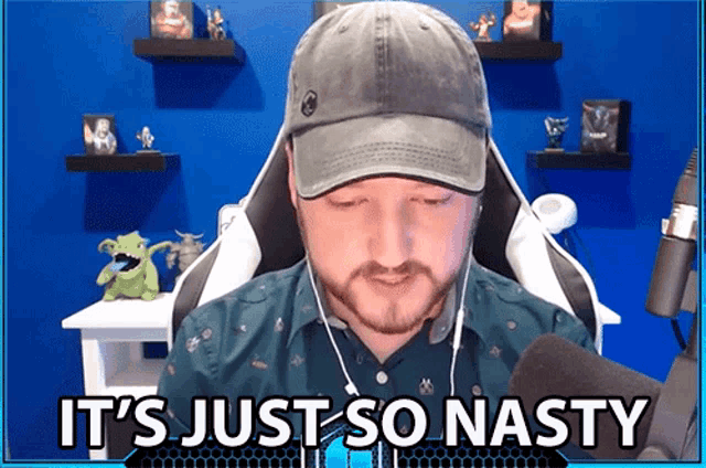 a man wearing a hat and ear buds says " it 's just so nasty "