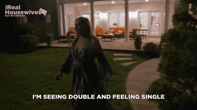 a woman is walking in front of a house with the words i 'm seeing double and feeling single above her