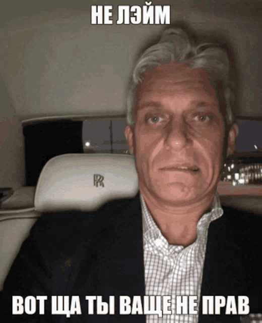 a man in a suit is sitting in a rolls royce car