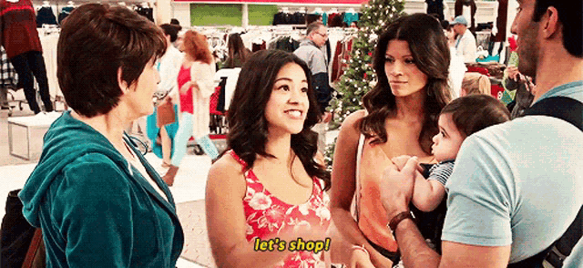 a group of people are standing in a store talking to each other and one woman is saying let 's shop .