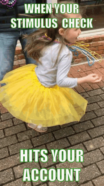 a little girl wearing a yellow tutu is dancing on a brick sidewalk