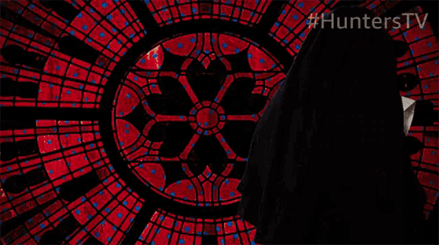 a nun is holding a gun in front of a stained glass window with #hunterstv written on the bottom