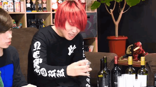 a man with red hair wears a black shirt with chinese writing on the sleeve