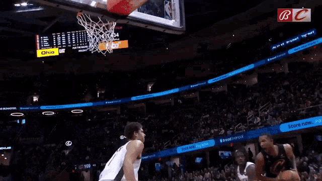 a basketball game is being played in a stadium with a score now pay later sign