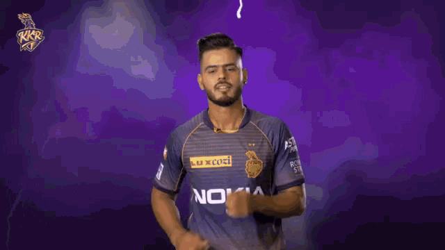 a man wearing a nokia shirt is dancing in front of a purple background