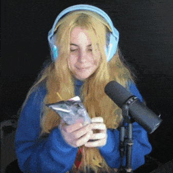 a girl wearing headphones is holding a bag of food in front of a microphone