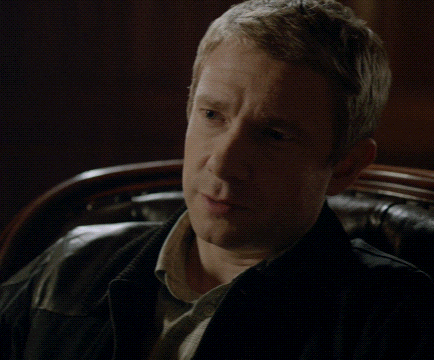 a man is sitting in a chair with his finger to his lips