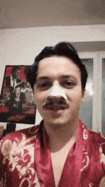 a man with a bandage on his nose stands in front of a movie poster for pulp fiction