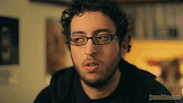 a man wearing glasses and a black shirt has the website jeuxvideo.com at the bottom