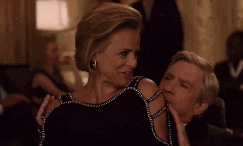 a man and a woman are sitting next to each other at a party .