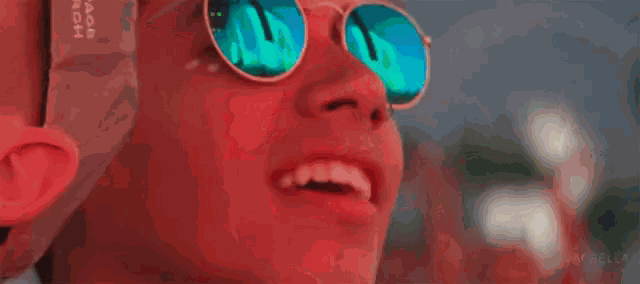 a close up of a person wearing sunglasses and a lollipop