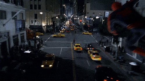 a man in a spiderman costume is flying over a street