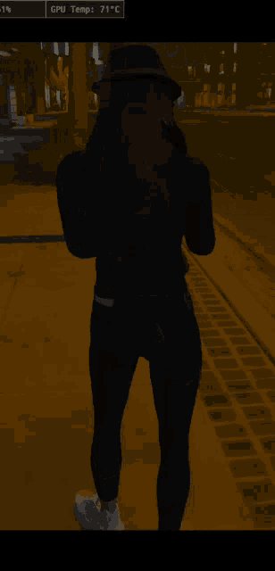 a woman standing on a sidewalk with a gpu temp of 71 degrees celsius