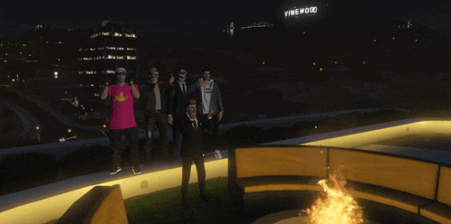 a group of people are standing in front of a sign that reads vinewood