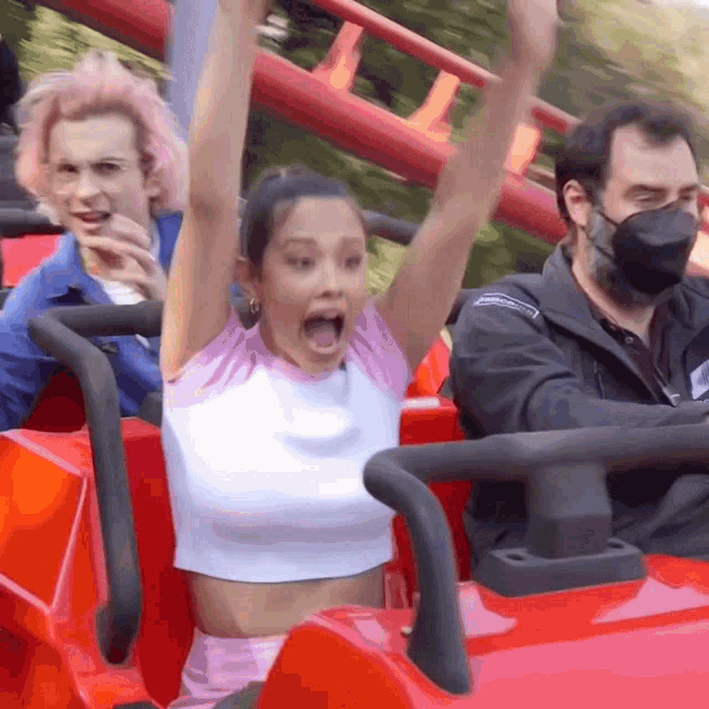 a woman is riding a roller coaster wearing a face mask