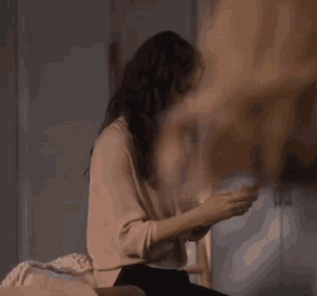 a woman is sitting on a couch and looking at her phone