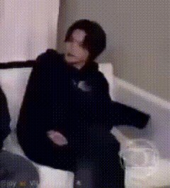a person is sitting on a couch with their arms outstretched and their legs crossed .