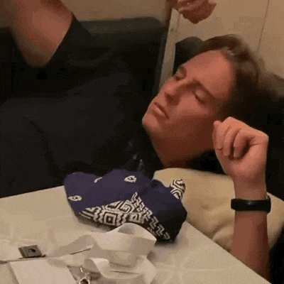 a man is laying on a couch with his head on a table .
