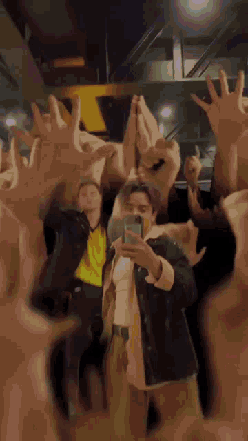 a man is taking a picture of himself in a crowd of hands