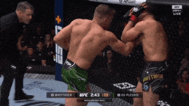 two men are fighting in a boxing ring and one of them is wearing shorts that say whitaker on them
