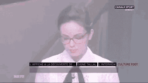a woman wearing glasses and a white shirt is on a tv screen that says canal + sport