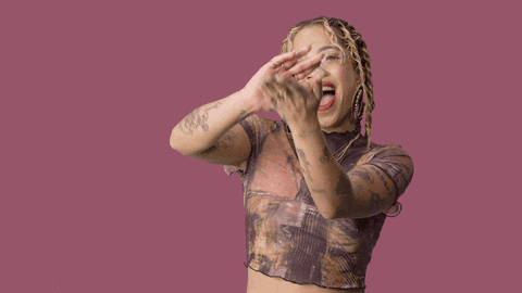 a woman with tattoos on her arms is covering her face