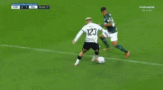 a soccer goalie jumps to catch a ball in front of a facebook banner