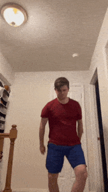 a man in a red shirt and blue shorts is dancing
