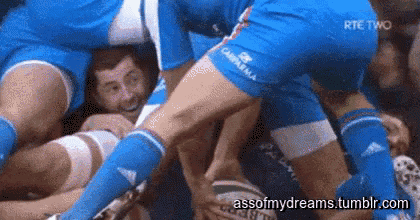 a group of men are playing a game of rugby and one of them is holding a ball .
