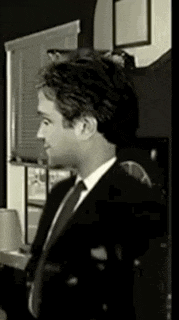 a man in a suit and tie is standing in a room