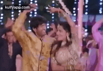 a man and a woman are dancing together in a room with a lot of lights .