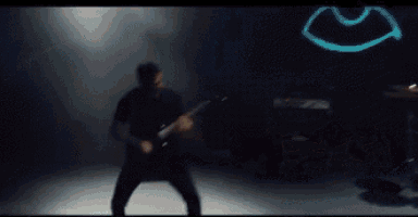 a person is playing drums in a dark room