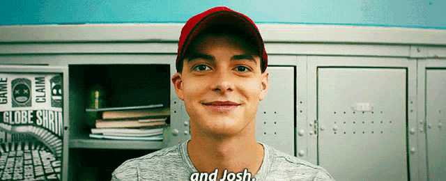 a young man wearing a red baseball cap and a grey shirt says " and josh "