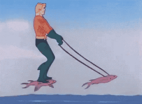 a man in a superhero costume is riding two fish on a leash .