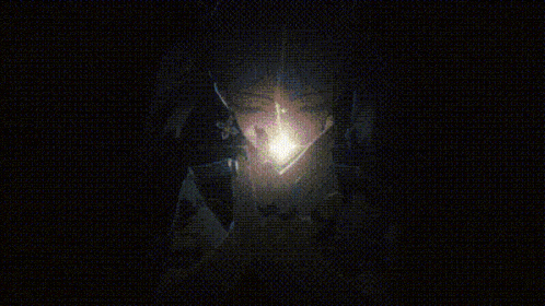 a close up of a person 's face with a light coming out of it in a dark room .