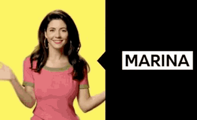 a woman in a pink shirt is dancing in front of a sign that says marina .