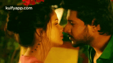 a man and a woman are kissing each other in a movie scene .